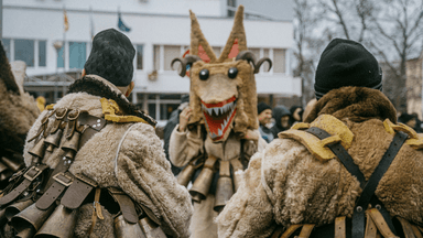 Muži v maskách pri tradičním festivale Kukeri v Bansku